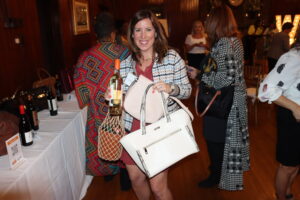 An attendee poses with a purse and a raffle prize.