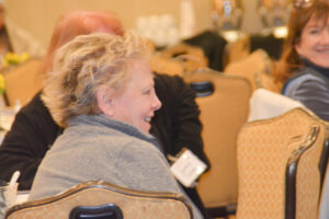 Conference attendee with short blonde hair smiling.