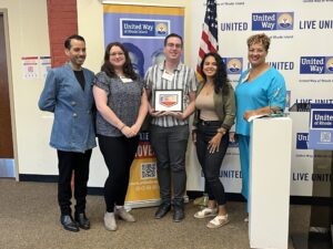 United Way of Rhode Island's Kevin Matta and Lifespan's Christin Zollicoffer posing with three Justice Assistance staff.